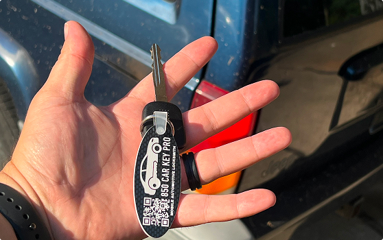 A hand holding a set of keys with an 850 Car Key Pro key chain attached.